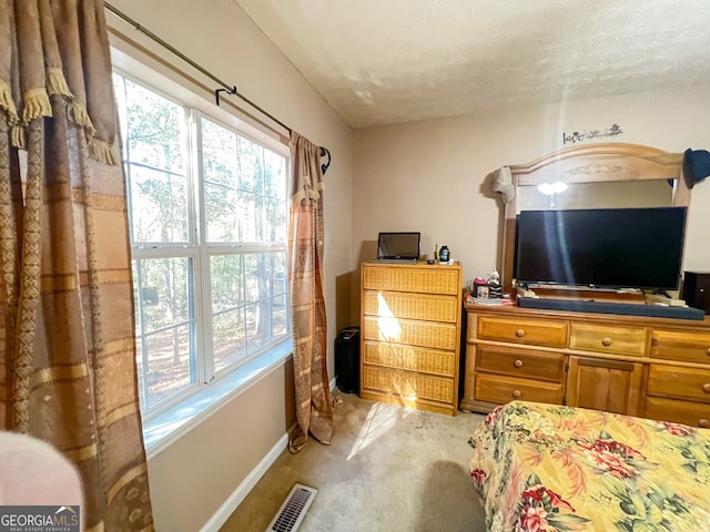 carpeted bedroom featuring a textured ceiling