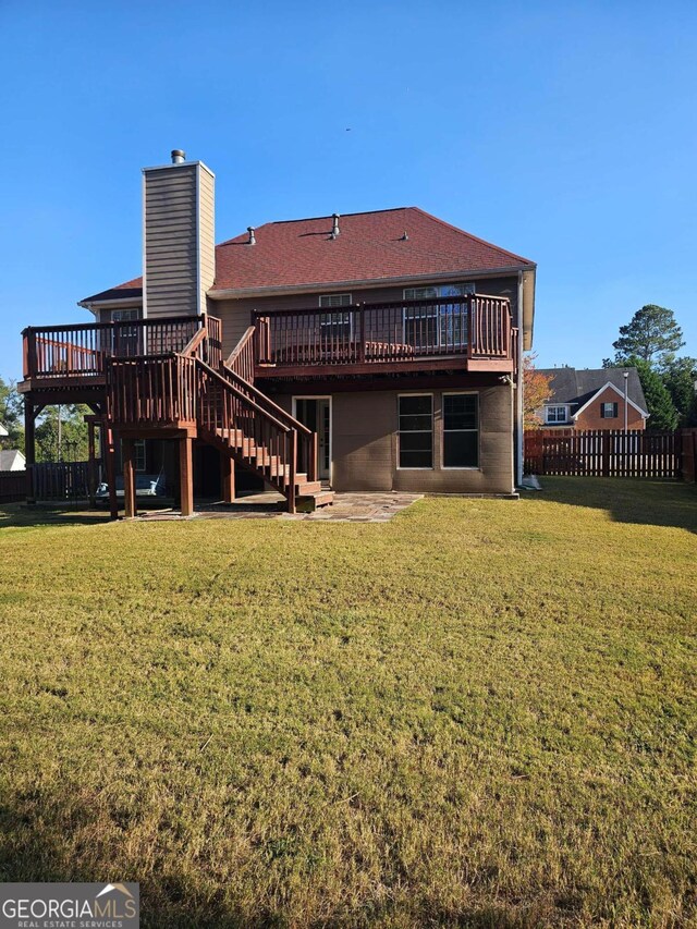 rear view of property with a yard and a deck