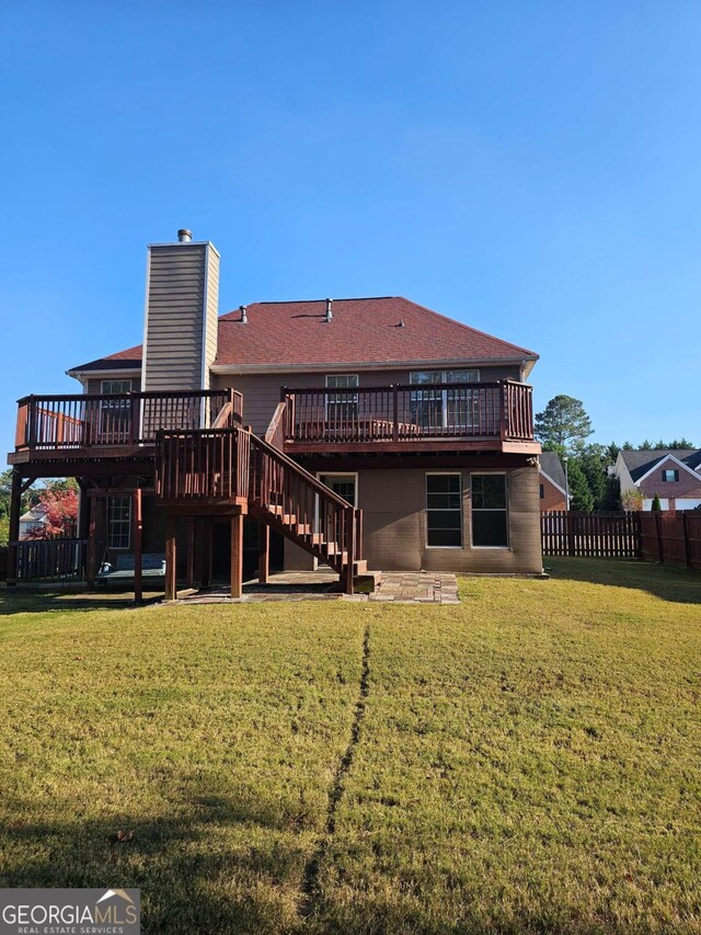 back of property featuring a deck and a yard