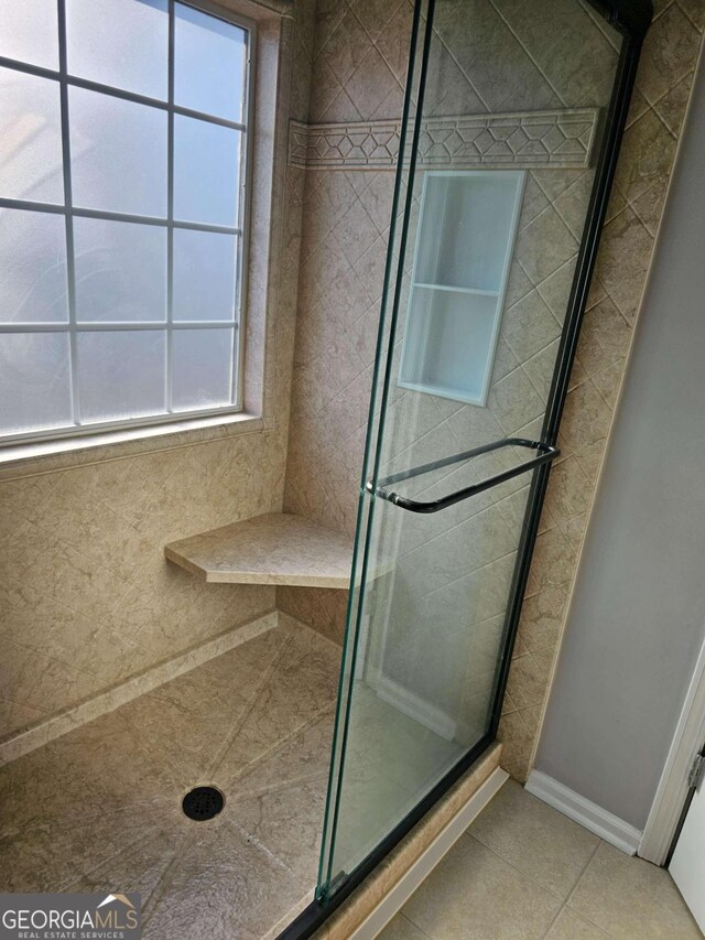 bathroom featuring tile patterned flooring and a shower with door