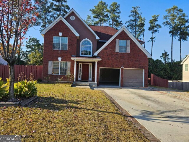 view of property with a garage and a front lawn