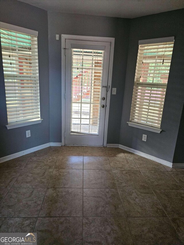 doorway with dark tile patterned flooring