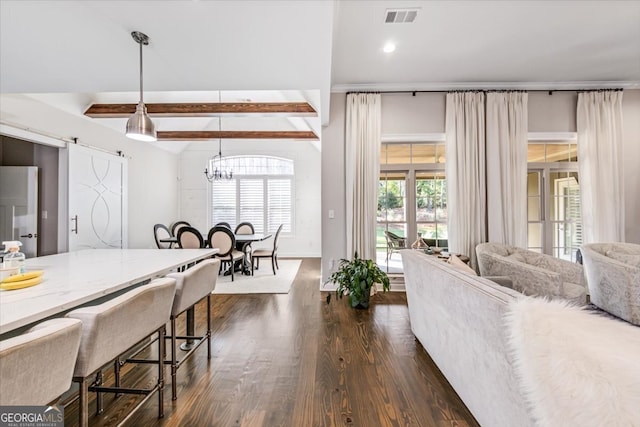 interior space featuring dark hardwood / wood-style flooring, a barn door, a notable chandelier, and lofted ceiling with beams