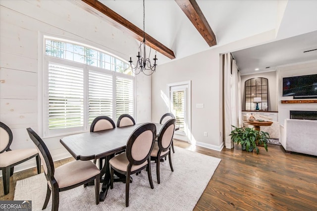 dining space with wood walls, lofted ceiling with beams, dark hardwood / wood-style flooring, and a notable chandelier