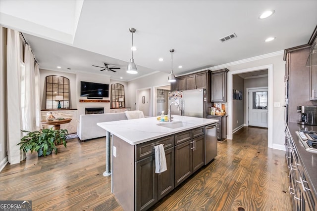 kitchen featuring stainless steel appliances, sink, light stone counters, a kitchen island with sink, and dark hardwood / wood-style flooring