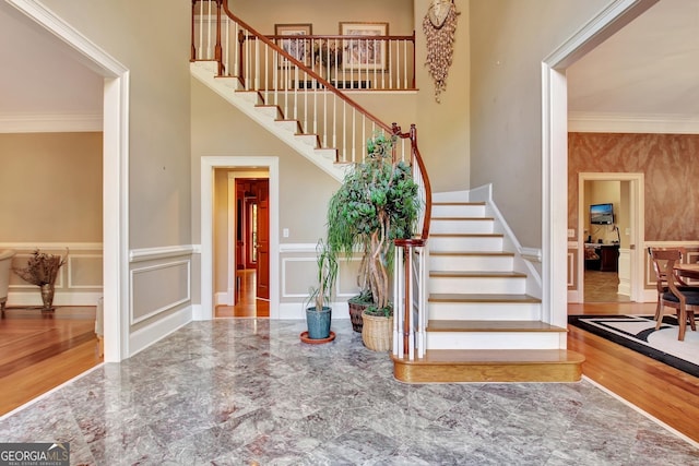 foyer entrance featuring crown molding and a towering ceiling