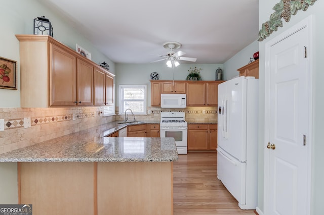 kitchen featuring ceiling fan, sink, kitchen peninsula, white appliances, and light wood-type flooring