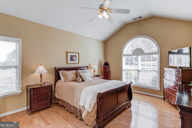 bedroom featuring ceiling fan, lofted ceiling, light hardwood / wood-style flooring, and multiple windows