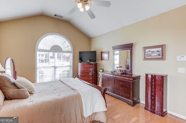 bedroom with multiple windows, ceiling fan, light hardwood / wood-style flooring, and lofted ceiling