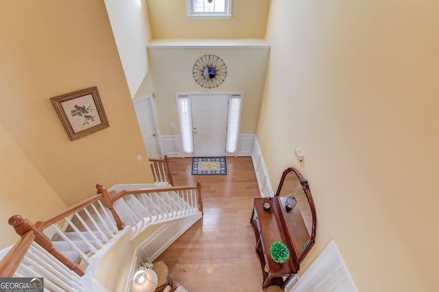 foyer entrance featuring wood-type flooring and a high ceiling