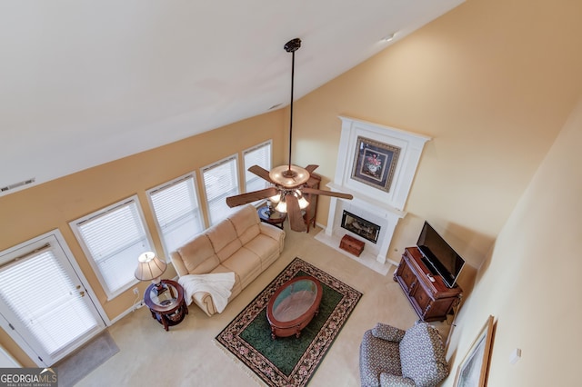 carpeted living room featuring high vaulted ceiling, ceiling fan, and a healthy amount of sunlight