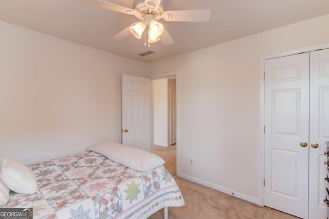 carpeted bedroom with ceiling fan and a closet