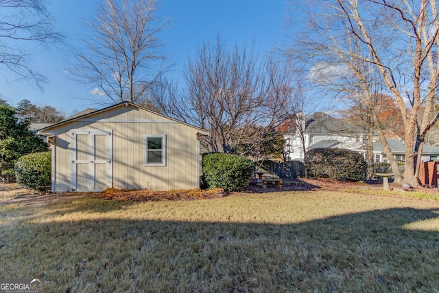 view of side of home with a shed and a lawn