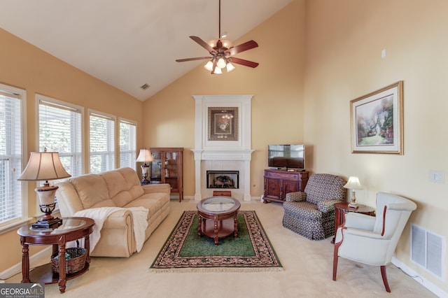 living room featuring carpet flooring, high vaulted ceiling, ceiling fan, and a tiled fireplace