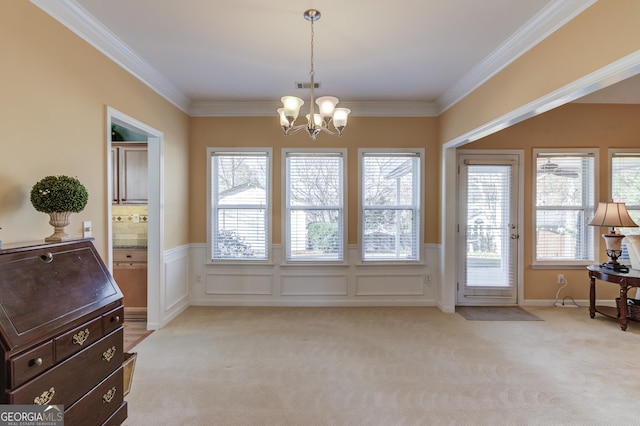 doorway with a notable chandelier, light colored carpet, and ornamental molding