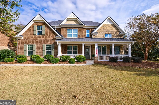 craftsman-style home featuring a porch and a front lawn