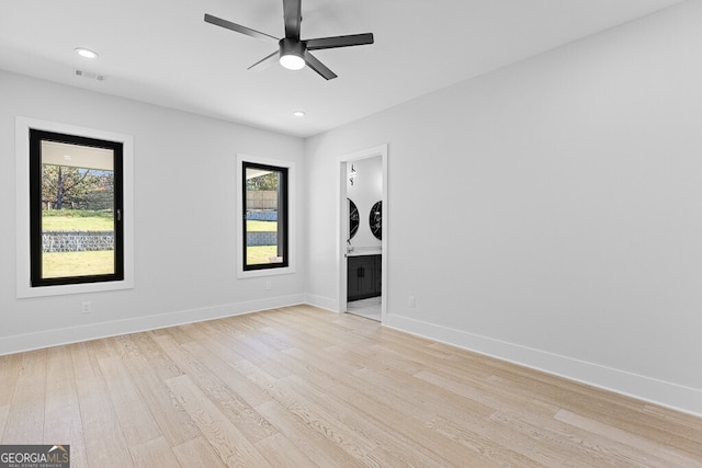 spare room featuring ceiling fan, a healthy amount of sunlight, and light wood-type flooring