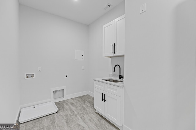 washroom with sink, cabinets, electric dryer hookup, hookup for a washing machine, and light wood-type flooring