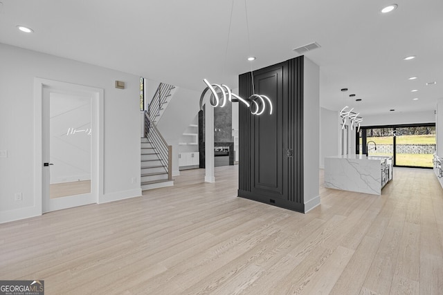 unfurnished living room featuring light wood-type flooring and sink