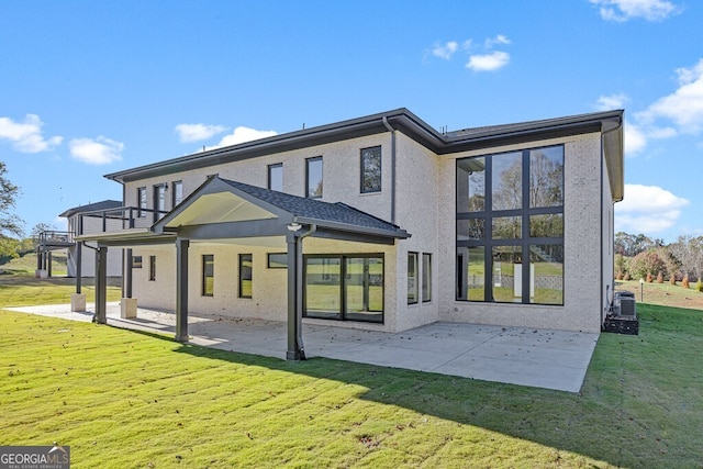 back of house featuring a lawn, central AC, a balcony, and a patio