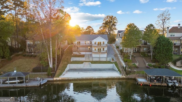 rear view of property with a water view, boat lift, and stairway