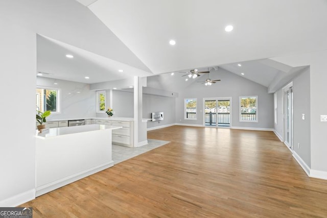 unfurnished living room featuring light wood-type flooring, high vaulted ceiling, baseboards, and recessed lighting