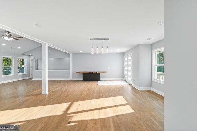 unfurnished living room with recessed lighting, wood finished floors, a ceiling fan, and baseboards