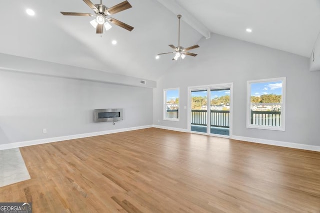 unfurnished living room featuring a ceiling fan, beamed ceiling, light wood-style flooring, and baseboards