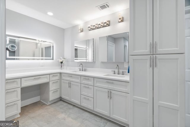 bathroom with visible vents, a sink, and double vanity