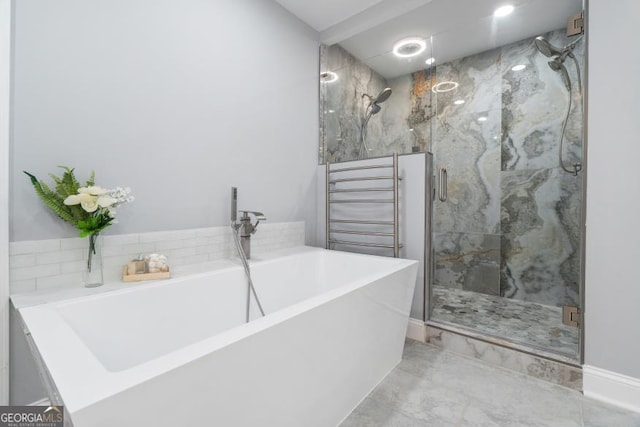 bathroom with a soaking tub and a shower stall