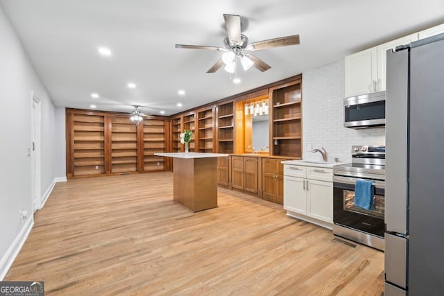 kitchen featuring stainless steel appliances, light wood-type flooring, white cabinetry, and open shelves