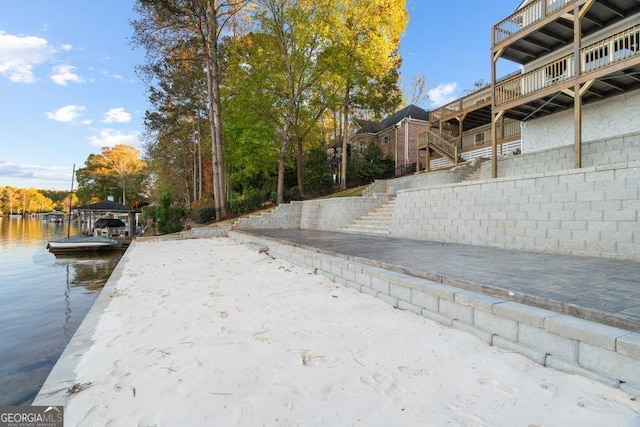 exterior space featuring stairs, a dock, and a water view