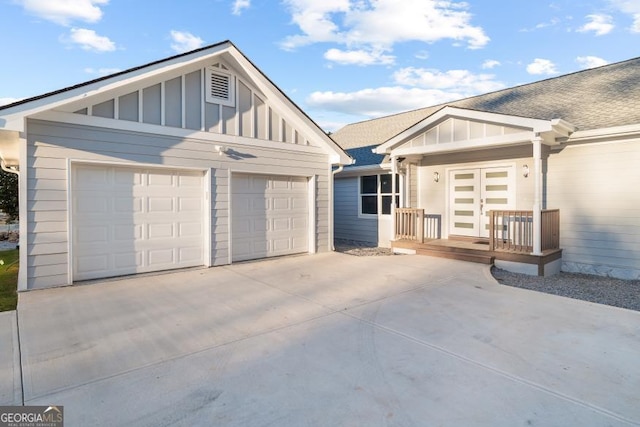 view of front of property featuring board and batten siding, concrete driveway, roof with shingles, and a garage