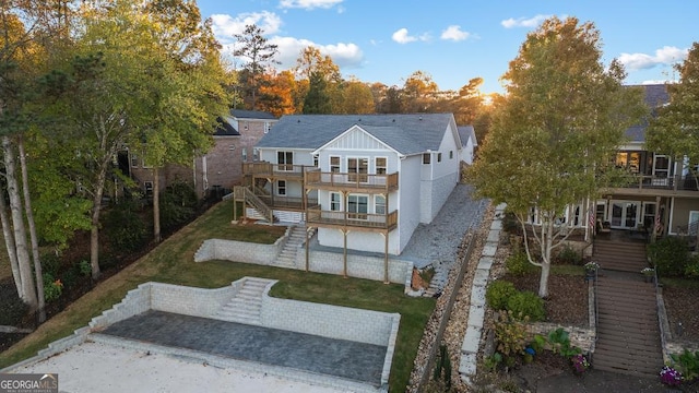 back of property featuring a yard, a patio, stairway, and a balcony