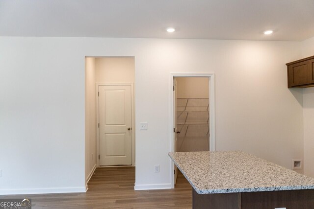 89 Hampton Ridge Way, Jefferson, GA 30549 - kitchen featuring wood finished floors, baseboards, light stone counters, a kitchen island, and recessed lighting