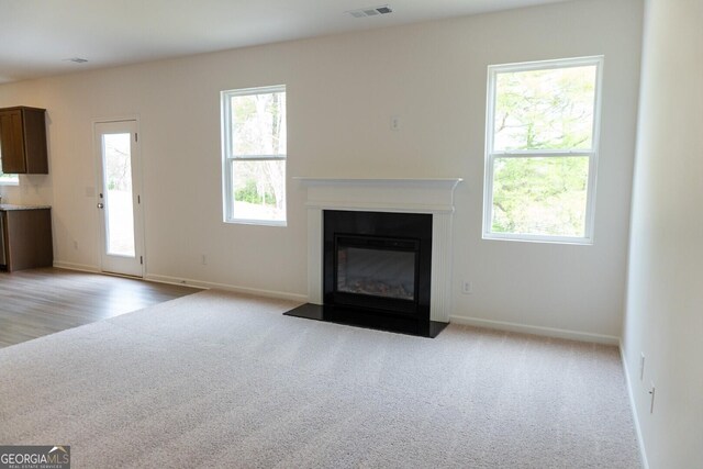 89 Hampton Ridge Way, Jefferson, GA 30549 - unfurnished living room featuring a fireplace with flush hearth, carpet flooring, and baseboards