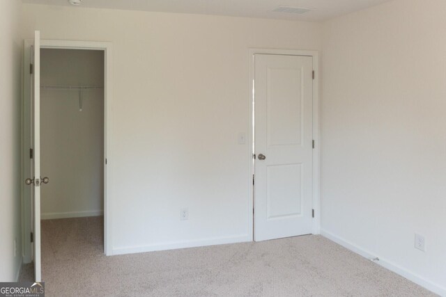 89 Hampton Ridge Way, Jefferson, GA 30549 - unfurnished bedroom featuring carpet flooring, a walk in closet, a closet, and baseboards