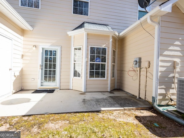 view of exterior entry with cooling unit and a patio