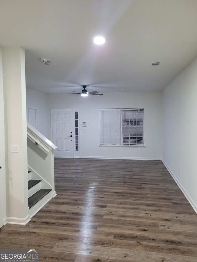 unfurnished living room with dark hardwood / wood-style floors and ceiling fan