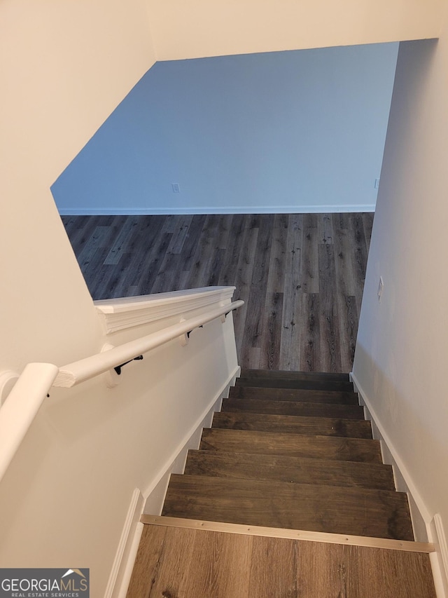 staircase with hardwood / wood-style floors