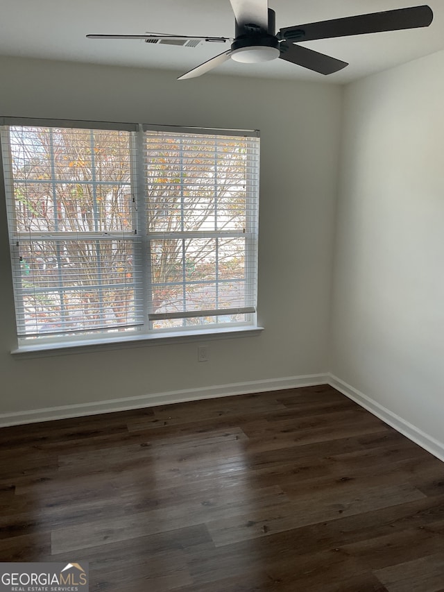 empty room with a healthy amount of sunlight and dark hardwood / wood-style floors