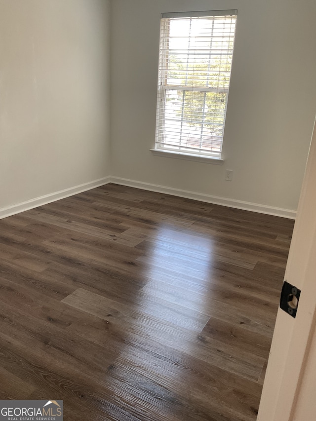 spare room with dark hardwood / wood-style floors