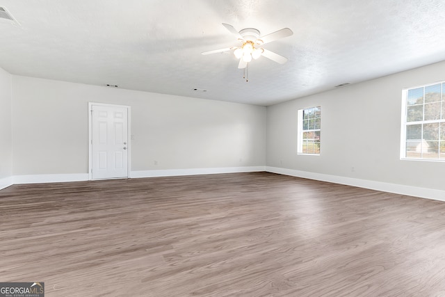 spare room with hardwood / wood-style flooring, ceiling fan, and a textured ceiling