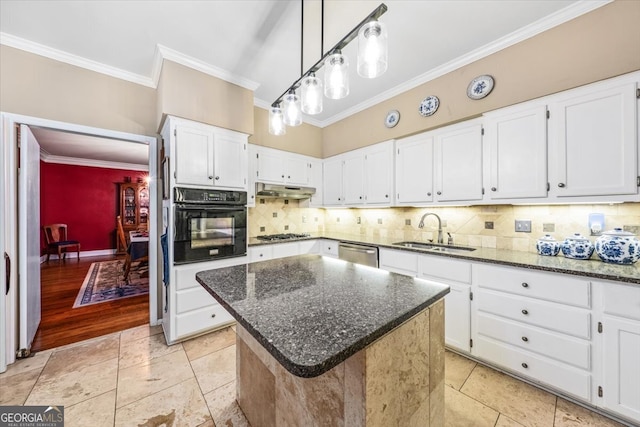 kitchen featuring sink, appliances with stainless steel finishes, crown molding, a center island, and white cabinets