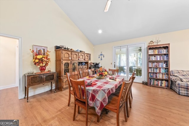 dining room featuring high vaulted ceiling and light hardwood / wood-style floors