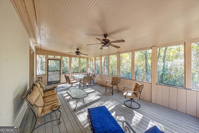 unfurnished sunroom with ceiling fan