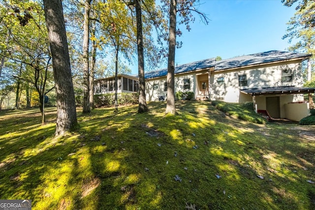 view of front facade with a front lawn and a sunroom