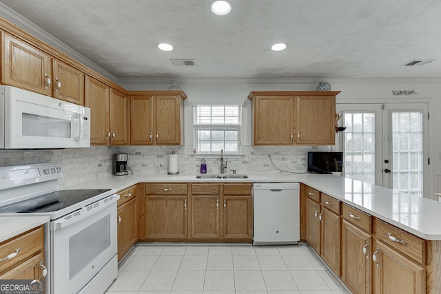 kitchen featuring kitchen peninsula, sink, ornamental molding, backsplash, and white appliances