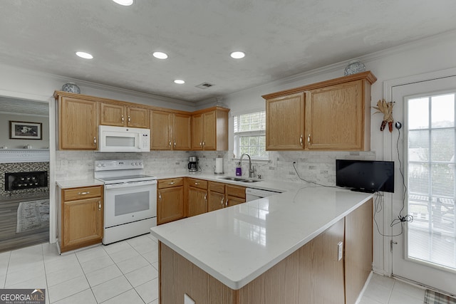 kitchen with crown molding, white appliances, light tile patterned floors, sink, and kitchen peninsula