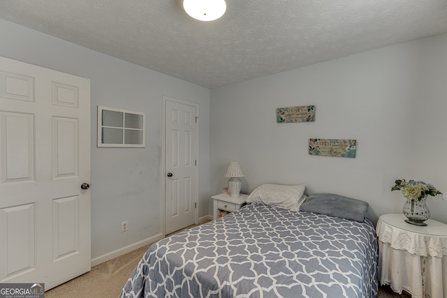 bedroom featuring a textured ceiling and light colored carpet